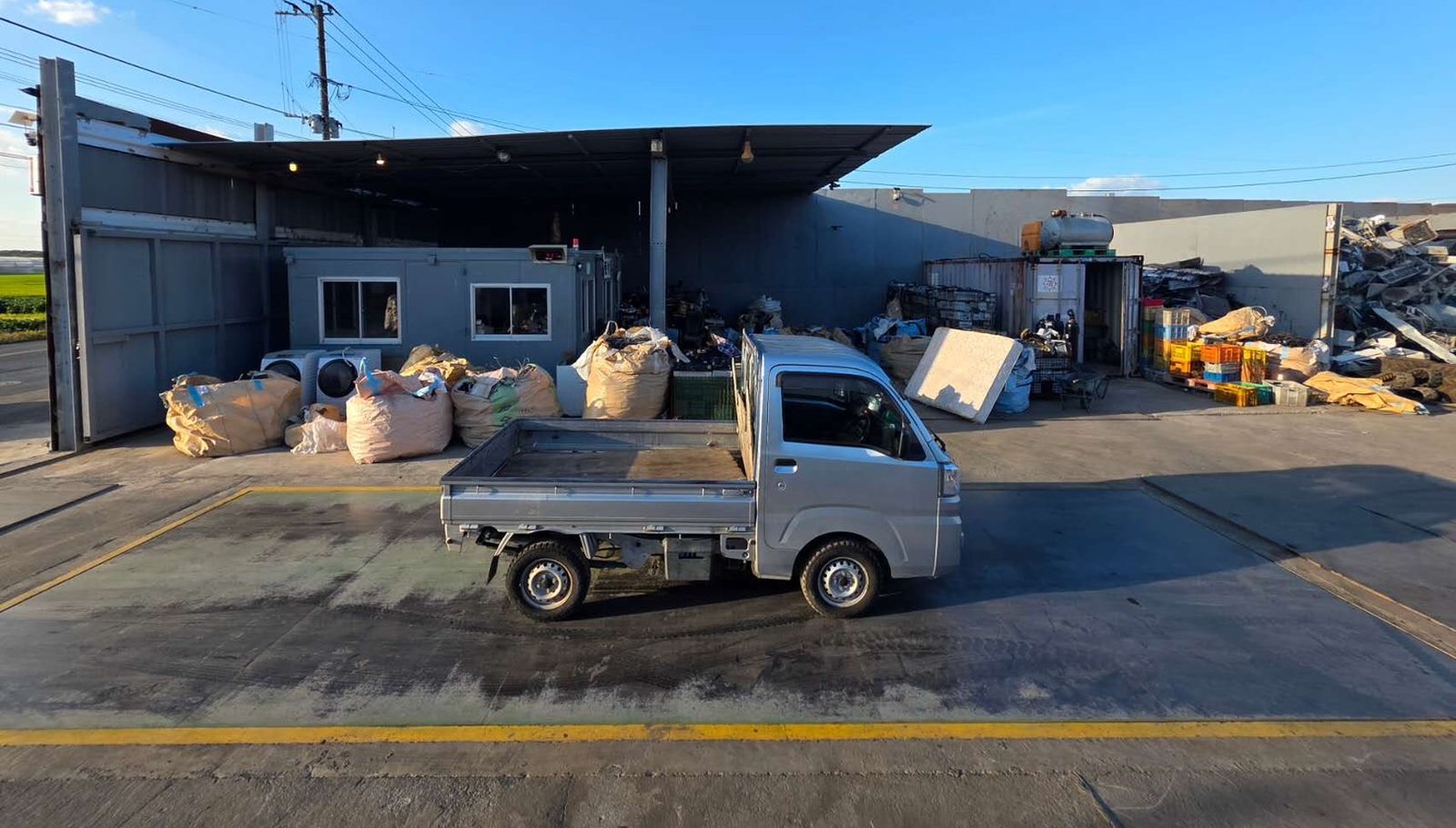 40tまで量れるトラック計量器に軽トラックが乗っている。奥に受付の建物